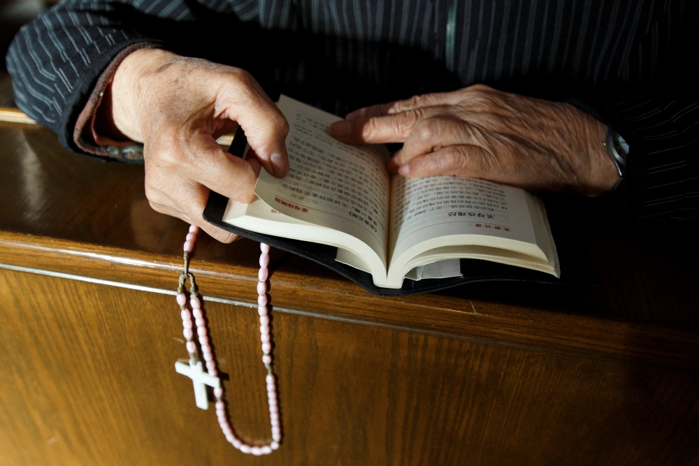 A believer reads the Bible during mass at St Josephs’ Church, a government-sanctioned Catholic church, in Beijing, October 1, 2018. Reuters / Thomas Peter