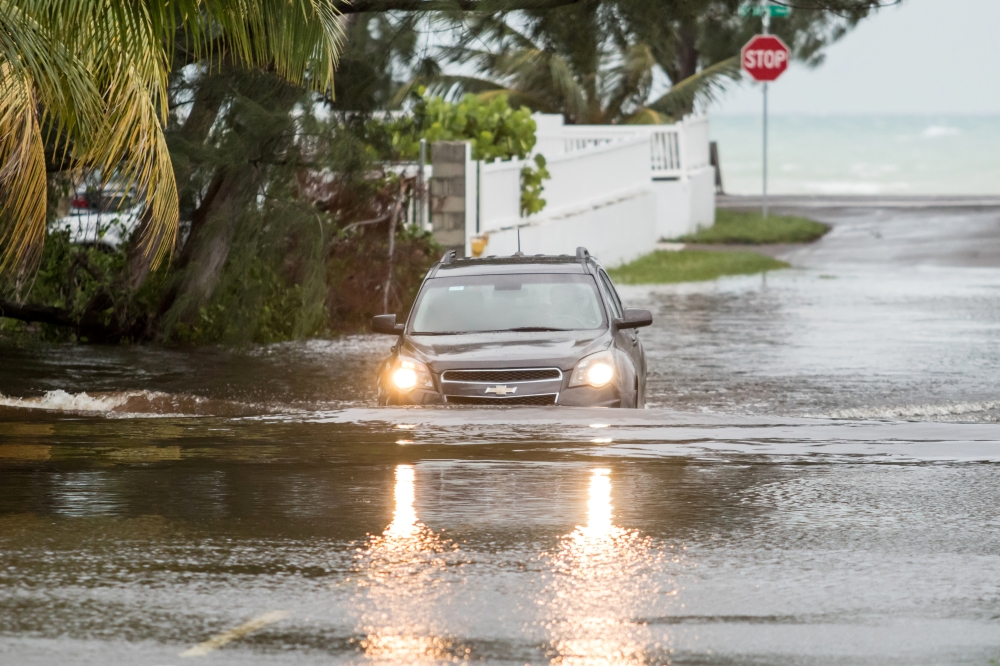 A car drives through a flooded street after the effects of Hurricane Dorian arrived in Nassau, Bahamas, September 2, 2019. REUTERS/John Marc Nutt