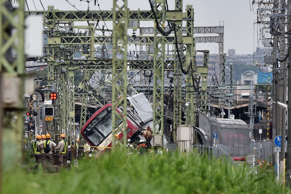 A train is seen derailed after a collision with a truck at a crossing in Yokohama, Kanagawa Prefecture on September 5, 2019. A train and a truck collided at a crossing near Tokyo, injuring 35 people, with at least one person seriously hurt, authorities sa