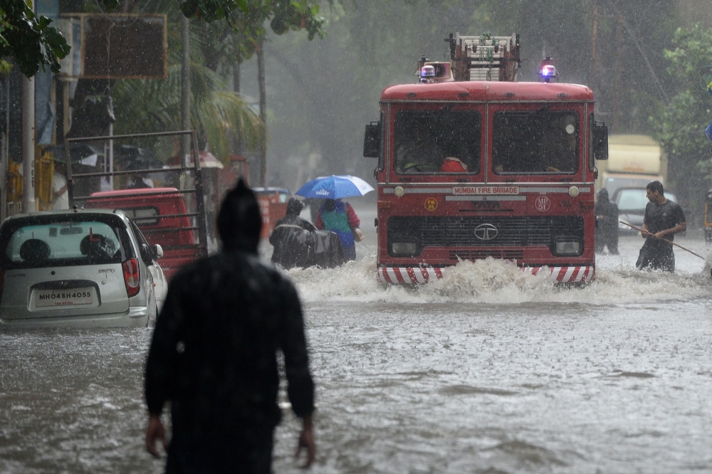 A fire engine drives through a flooded road during heavy rain showers in Mumbai on September 4, 2019. / AFP / PUNIT PARANJPE