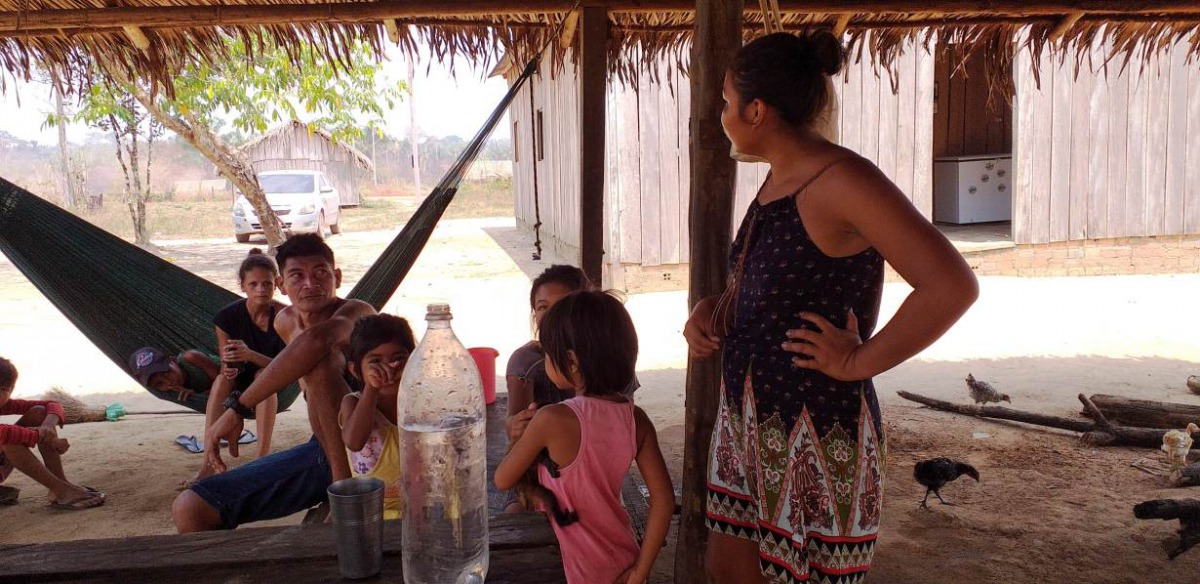 Members of the Tenharim indigenous community gather under a thatched roof in the state of Amazonas, Brazil, Sept. 1, 2019. Thomson Reuters Foundation/Fabio Teixeira
