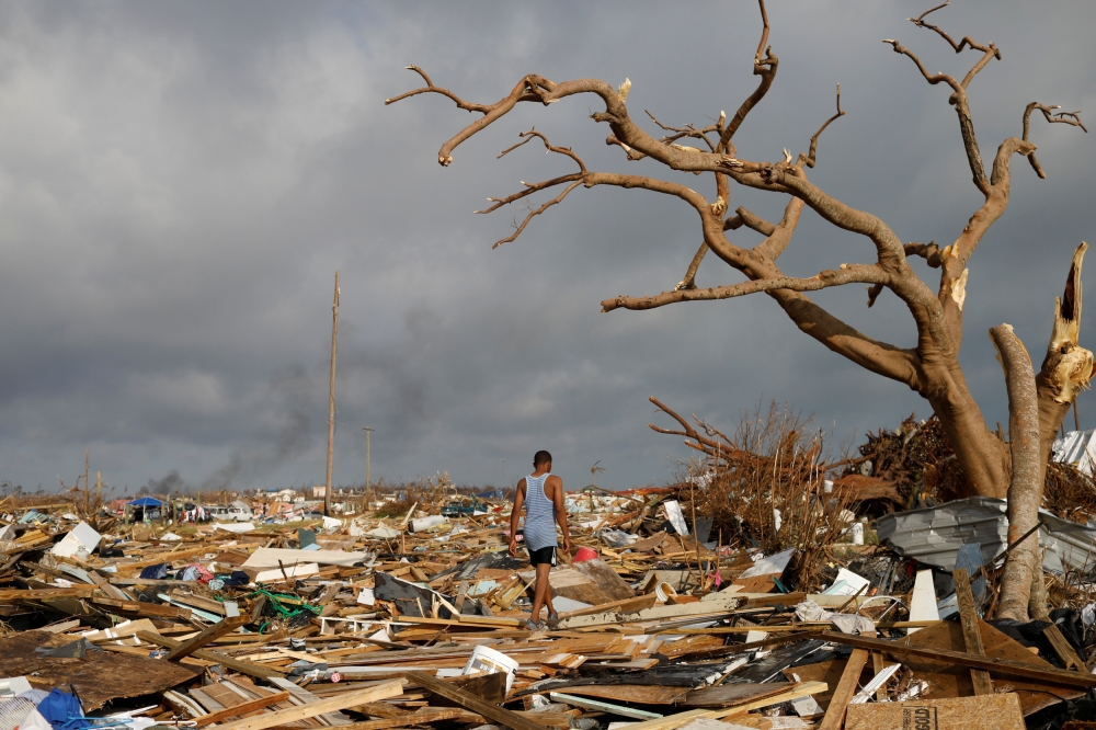 A man walks among debris at the Mudd neighborhood, devastated after Hurricane Dorian hit the Abaco Islands in Marsh Harbour, Bahamas, September 6, 2019. Reuters/Marco Bello