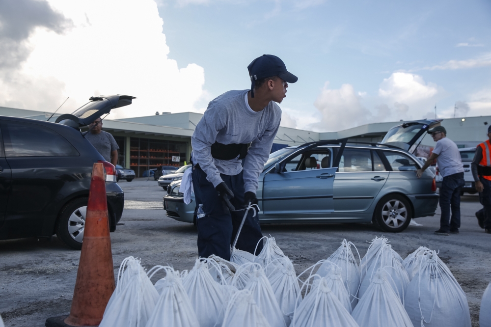 Miami Beach public works department workers fill sandbags and help load them into residents'cars in Miami Beach, Florida, August 31, 2019 in preparation for hurricane Dorian. AFP / Adam DelGiudice 