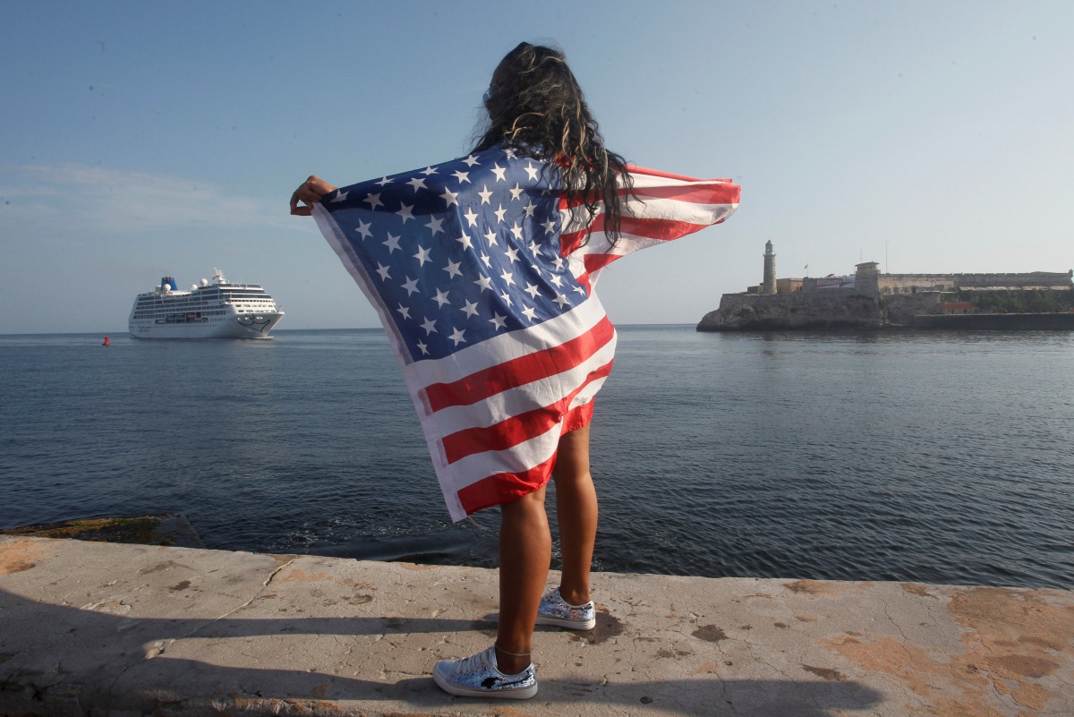 A woman with a US flags looks at the arrival of US Carnival cruise ship Adonia at the Havana bay, May 2, 2016. Reuters