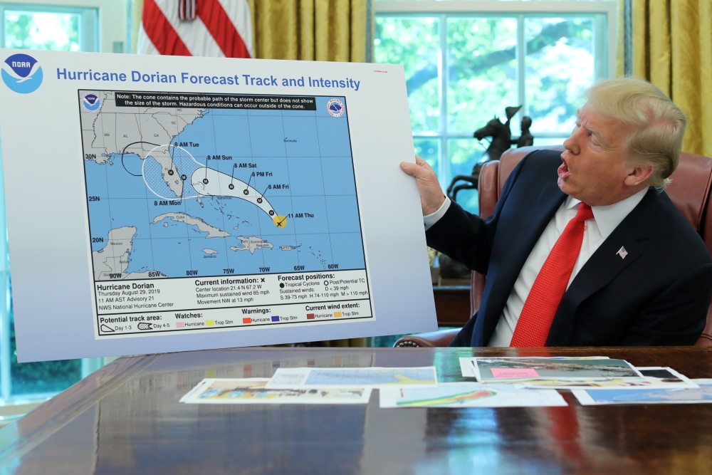 US President Donald Trump holds a chart showing the original projected track of Hurricane Dorian that appears to have been extended with a black line to include parts of the Florida panhandle and of the state of Alabama during a status report meeting on t