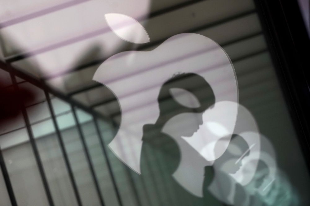FILE PHOTO: Apple company logos are reflected on the glass window outside an Apple store in Shanghai, China, Jan. 3, 2019. REUTERS/Aly Song