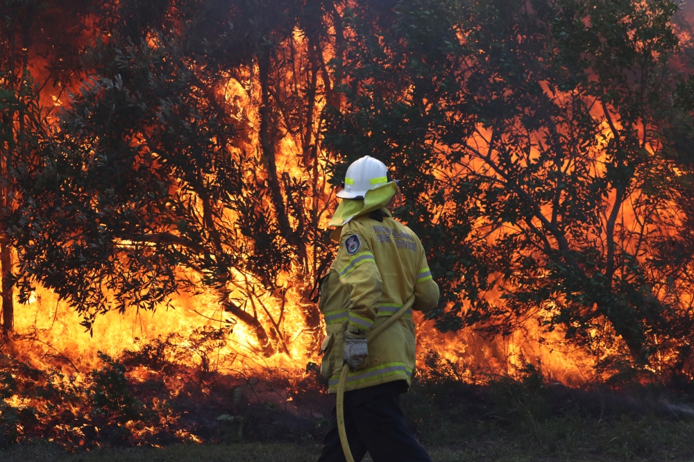 Firefighters battle bushfires in Angourie, northern New South Wales, Australia, September 10, 2019. AAP Image/Jason O'Brien/via REUTERS 