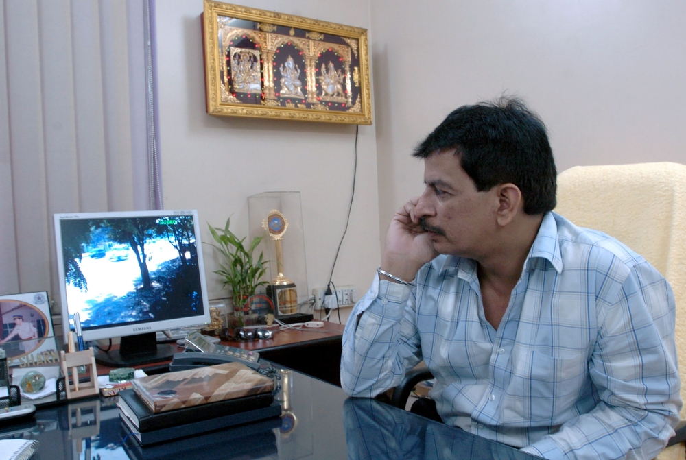 In this file photo taken on March 14, 2005 Mumbai police officer Pradeep Sharma watches a screen showing the entrance to his house in Mumbai. India's real-life Dirty Harry who made his name by gunning down gangsters in the streets of Mumbai has resigned a