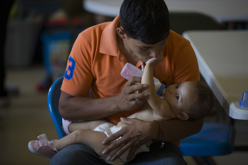 A man from Honduras feeds his daughter as they relax at the El Calvario Methodist Church which is housing migrants who are seeking asylum in Las Cruces, New Mexico. Joe Raedle/Getty Images/AFP