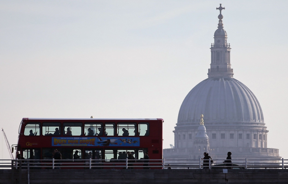 Commuters cross the River Thames' Waterloo Bridge into the City of London on March 21, 2018, backdropped by the dome of St Pauls Cathedral. AFP / Daniel Leal-Olivas