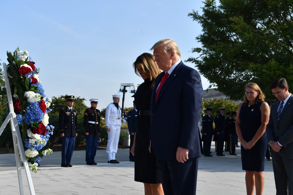US President Donald Trump and First Lady Melania Trump, with US Secretary of Defense Mark Esper (R) and his wife Leah Esper (2nd R), lay a wreath during a ceremony marking the 18th anniversary of the 9/11 attacks, on September 11, 2019, at the Pentagon in