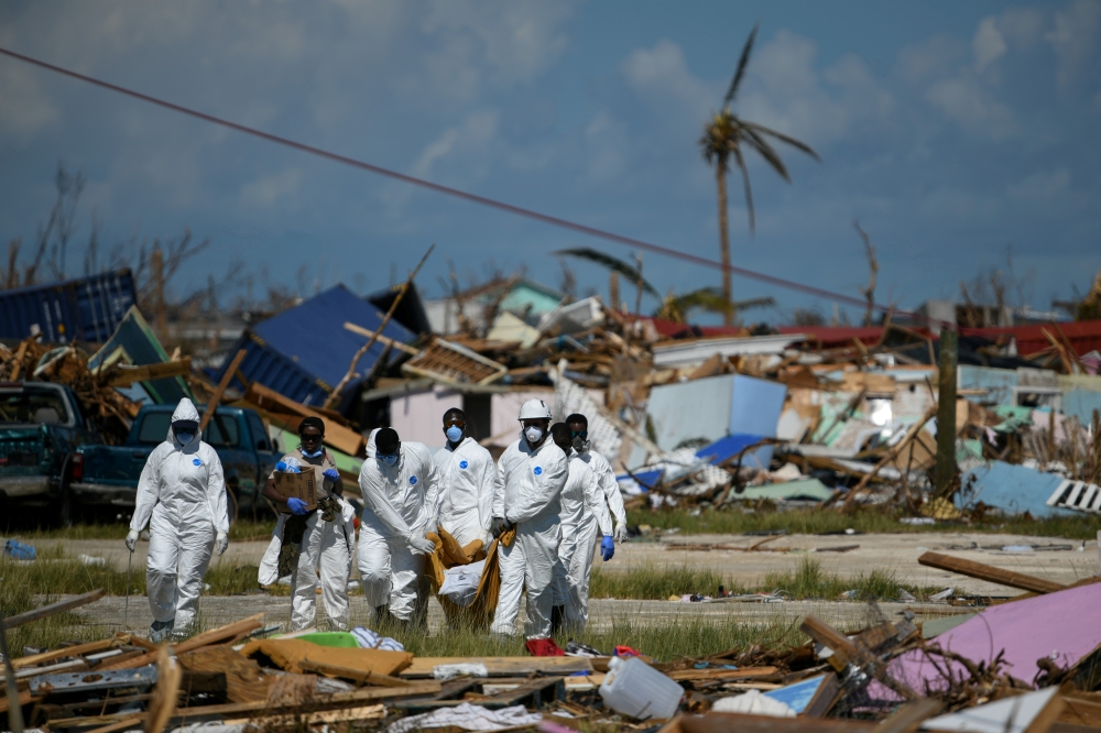 FILE PHOTO: Personnel from the Royal Bahamas Police Force remove a body recovered in a destroyed neighborhood in the wake of Hurricane Dorian in Marsh Harbour, Great Abaco, Bahamas, September 9, 2019. REUTERS/Loren Elliott