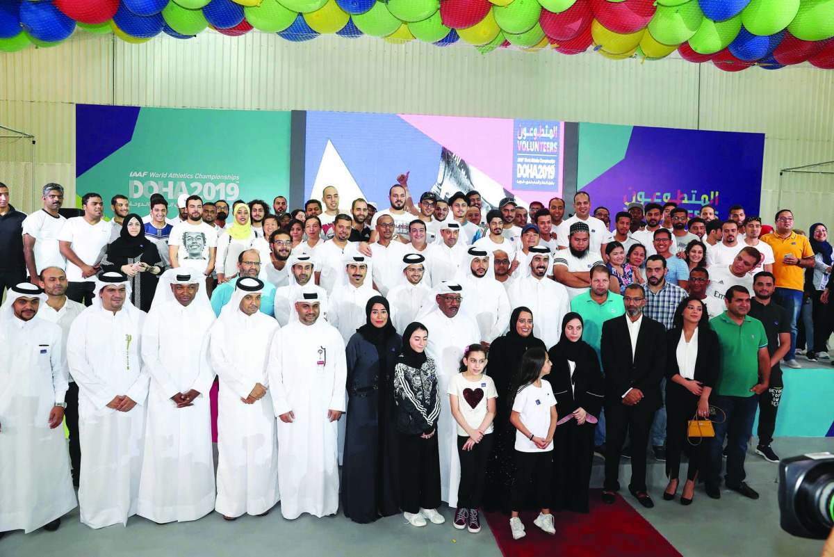 Volunteers pose for a picture along with officials of the organising committee of IAAF World Athletics Championships during the opening ceremony of the Volunteers Entertainment Tent in Doha yesterday. 