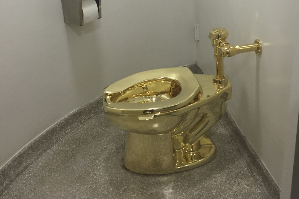 (FILES) In this file photo taken on September 15, 2016, a fully functioning solid gold toilet, made by Italian artist Maurizio Cattelan, is going into public use at the Guggenheim Museum in New York. AFP / William Edwards 