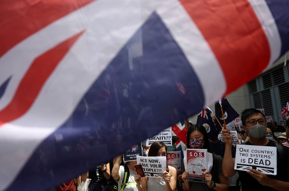 Anti-government protesters hold up banners, placards, Union Jack flags as they gather at the British consulate General in Hong Kong, China, September 15, 2019. REUTERS/Athit Perawongmetha