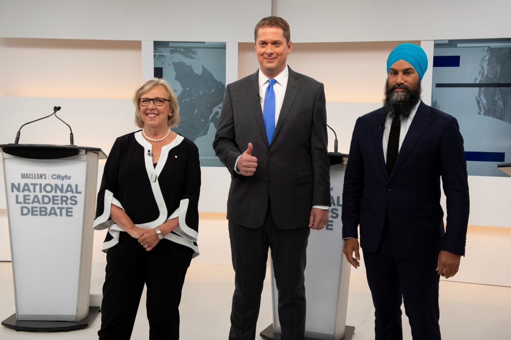 Green Party leader Elizabeth May, Conservative leader Andrew Scheer and New Democratic Party (NDP) leader Jagmeet Singh pose at the start of the Maclean's/Citytv National Leaders Debate on the second day of the election campaign in Toronto, Ontario, Canad