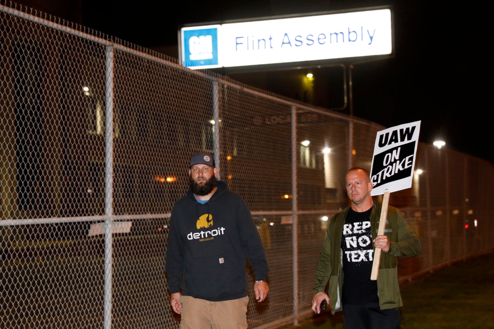 Members of the United Auto Workers (UAW) who are employed at the General Motors Co. Flint Assembly plant in Flint, Michigan, walk in front of the plant as they go on strike early on September 16, 2019. AFP / JEFF KOWALSKY