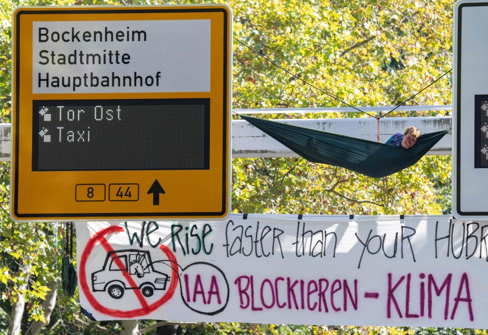 Demonstrators from the action group Sand im Getriebe (grit in the gears) calling for radical change in transport policy and in the motor industry have fixed a hammock and a banner reading 