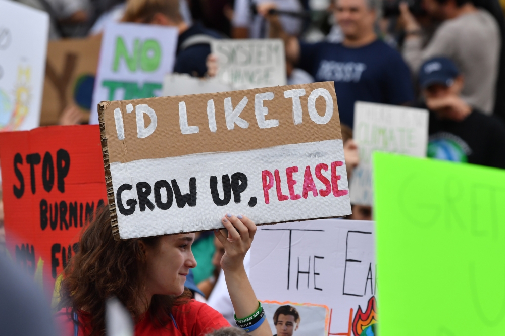 Teenagers and students take part in a climate protest outside the White House (background) in Washington on September 13, 2019. AFP / Nicholas Kamm
