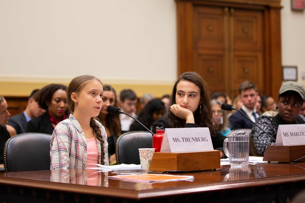 Swedish environment activist Greta Thunberg (L) speaks as This Is Zero Hour co-founder Jamie Margolin (C) and Alliance for Climate Education fellow Vic Barrett (R) look on during a joint hearing before the House Foreign Affairs Committee, Europe, Eurasia,