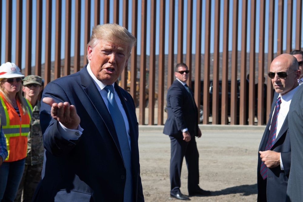 US President Donald Trump (L) speaks to the media during a visit the US-Mexico border fence in Otay Mesa, California on September 18, 2019. / AFP / Nicholas KAMM