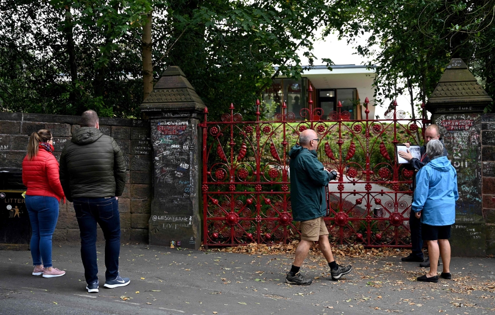 Visitors look at the gates to Strawberry Field in Liverpool, northwest England on September 18, 2019. AFP / Paul Ellis
 