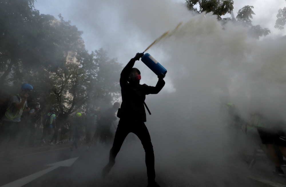 An anti-government protester uses a fire extinguisher during a march in Tuen Mun, Hong Kong, China September 21, 2019. REUTERS/Tyrone Siu