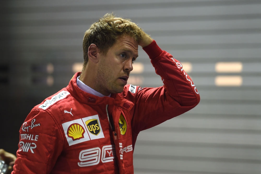 Ferrari's German driver Sebastian Vettel reacts after finishing in the third pole position in the qualifying session for the Formula One Singapore Grand Prix at the Marina Bay Street Circuit in Singapore on September 21, 2019. AFP / Mohd Rasfan 