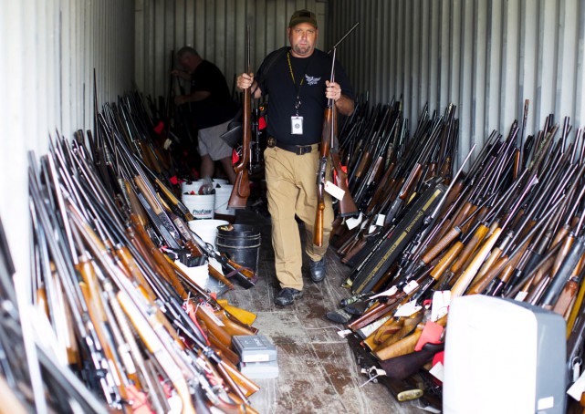 A Chesterfield County police officer sort through thousands of guns found in a home and garage in Pageland, South Carolina, November 10, 2015. Reuters
