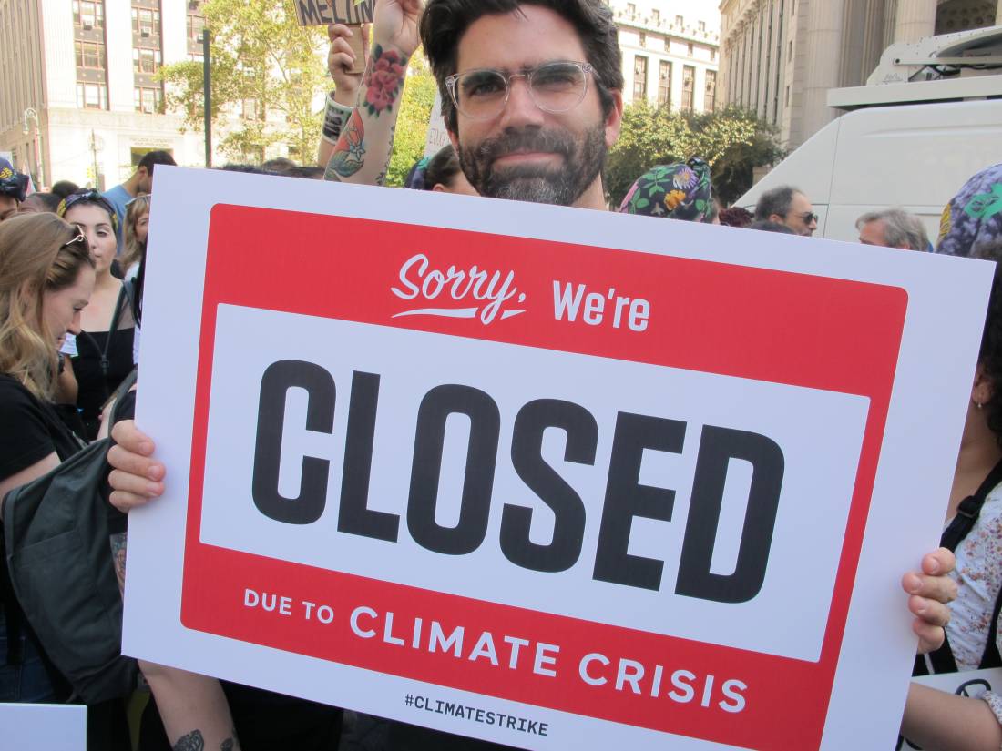Justin Flood, a graphic designer for an advertising agency and first-time climate protester, holds a protest sign in Manhattan's Foley Square in New York City, September 20, 2019. Thomson Reuters Foundation/Laurie Goering