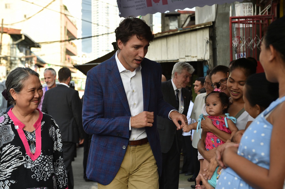Justin Trudeau greeting mothers at a clinic run by the non-governmental organisation Likhaan during a visit on the sidelines of the ASEAN summit