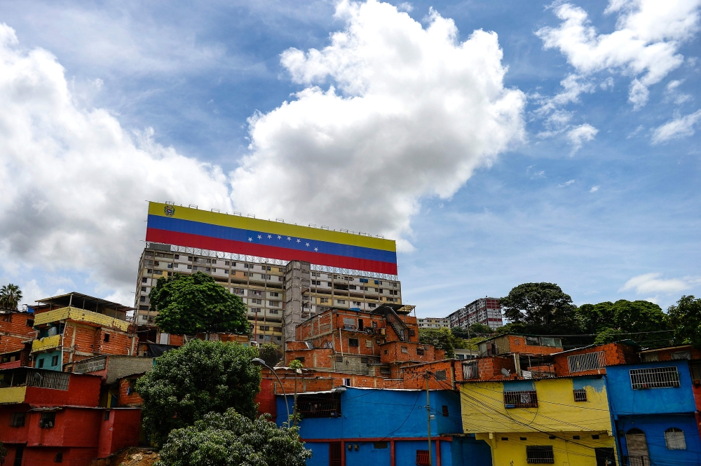 View of a giant Venezuelan national flag sign on top of a building in Caracas, Venezuela, on September 23, 2019. / AFP / Matias Delacroix