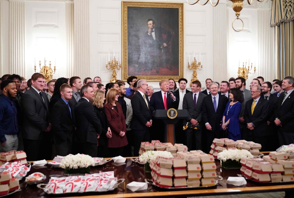 Donald Trump speaks behind a table of fast-food during an event in honor of the The North Dakota State Bison in the State Dining Room of the White House on March 4, 2019. AFP / Mandel Ngan