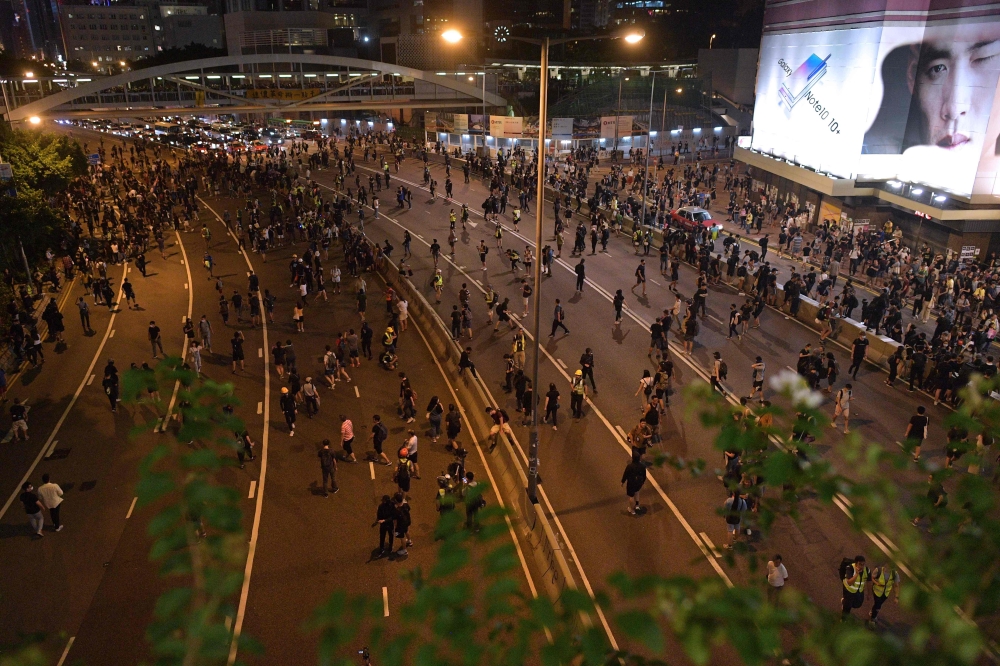 Protesters spill out into the main road near the government offices in the Admiralty area in Hong Kong on September 28, 2019, as activists mark the fifth anniversary of the 