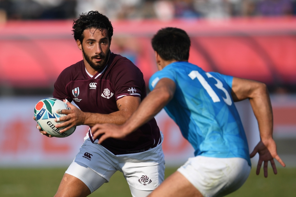 Georgia's centre Giorgi Kveseladze (L) runs with the ball during the Japan 2019 Rugby World Cup Pool D match between Georgia and Uruguay at the Kumagaya Rugby Stadium in Kumagaya on September 29, 2019. / AFP / CHARLY TRIBALLEAU