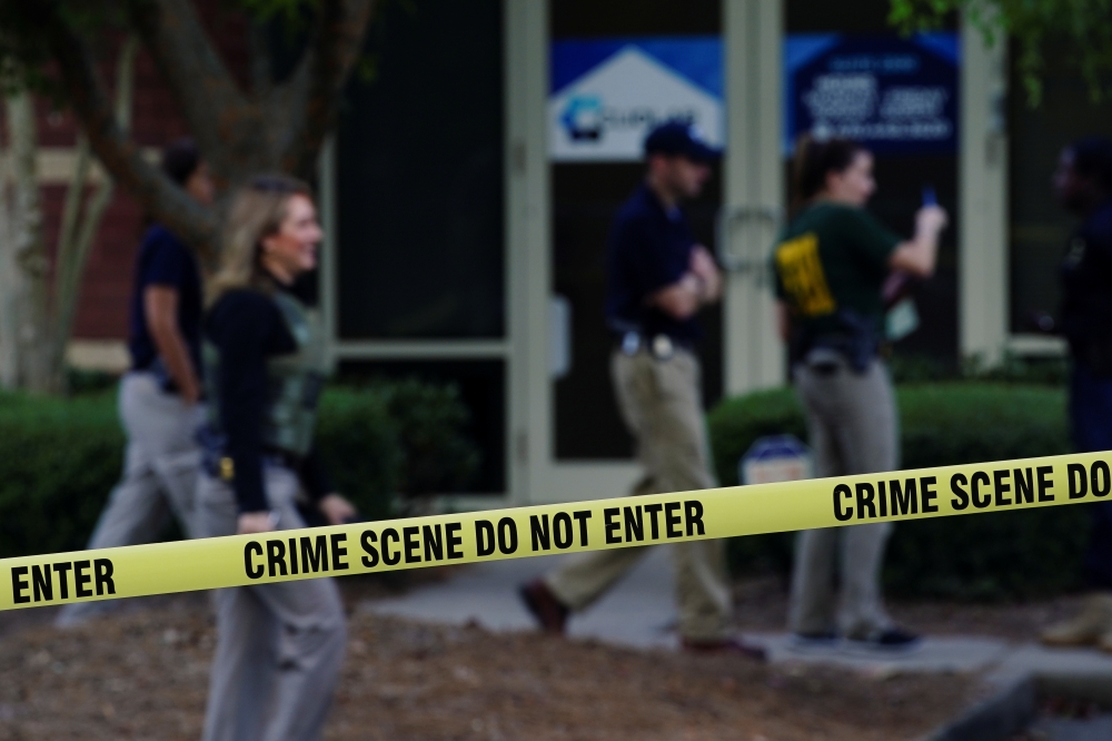 Federal agents are seen behind crime scene tape after executing search warrants on multiple businesses in Lawrenceville, Georgia U.S. September 27, 2019. Reuters/Elijah Nouvelage
