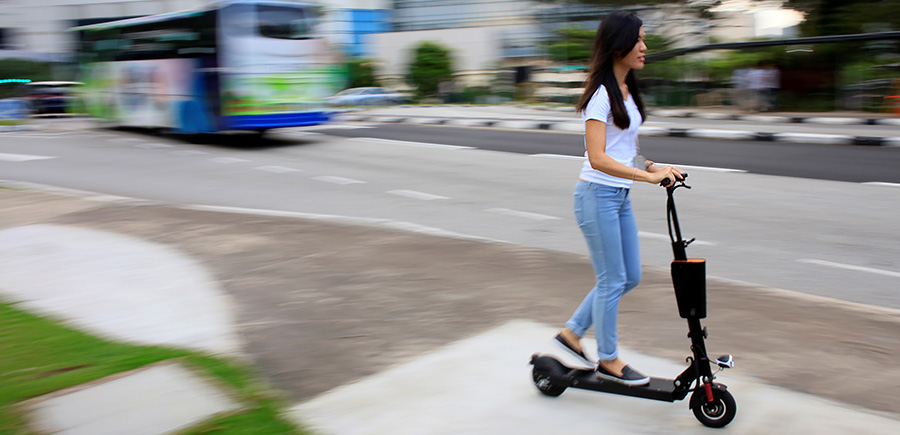 A woman rides a Neuron rental electric scooter in Singapore June 16, 2017. Reuters/Thomas White