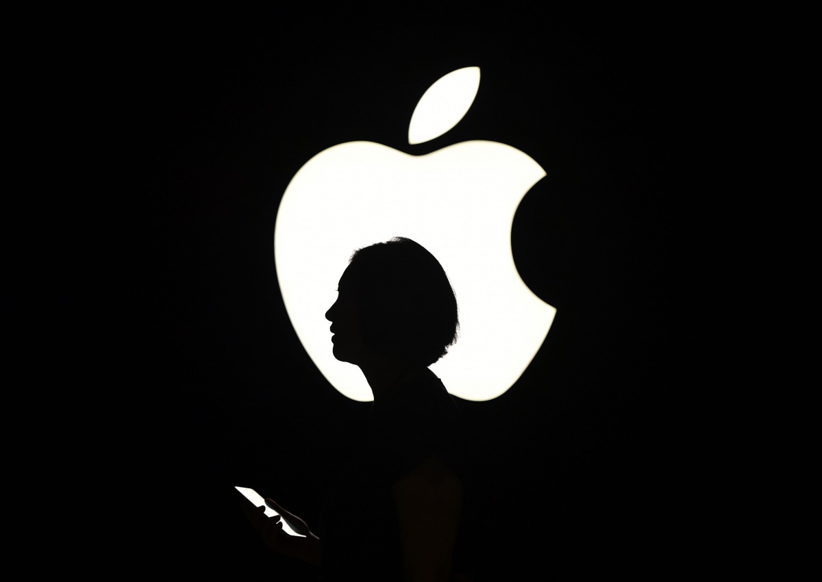 A reporter walk by an Apple logo during a media event in San Francisco, September 9, 2015. AFP/Josh Edelson