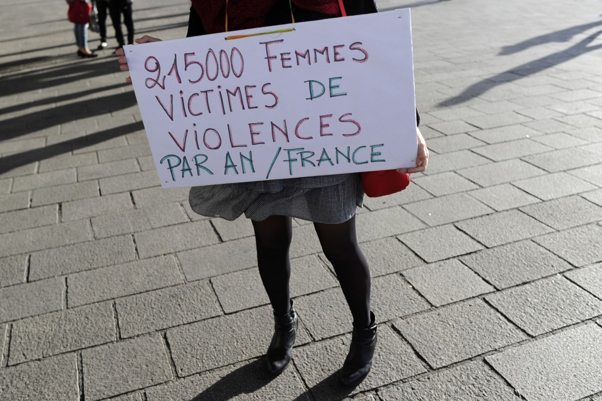 A woman holds a placard reading '21500 women victims of violence per year in France' as people gather for a rally at the Old Port of Marseille, southern France, on October 29, 2017. AFP / Franck Pennant