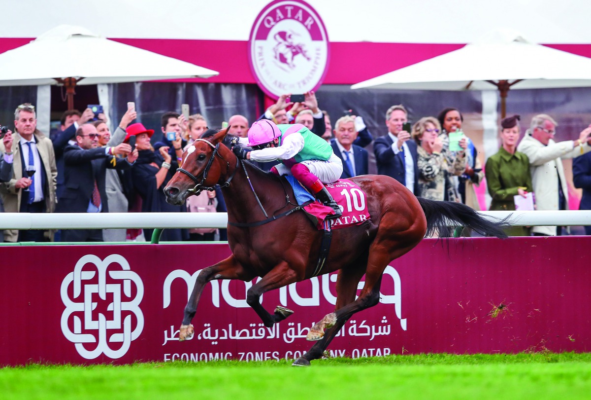 Action from last year’s Qatar Prix de l’Arc de Triomphe at ParisLongchamp. TOP LEFT: A woman walks past a billboard which promotes the premier racing weekend. 