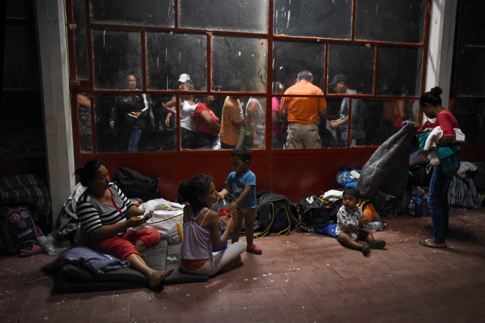 Central American migrants -taking part in a caravan called Migrant Viacrucis- rest at a sports center field in Matias Romero, Oaxaca state, Mexico on April 2, 2018. AFP / Victoria Razo