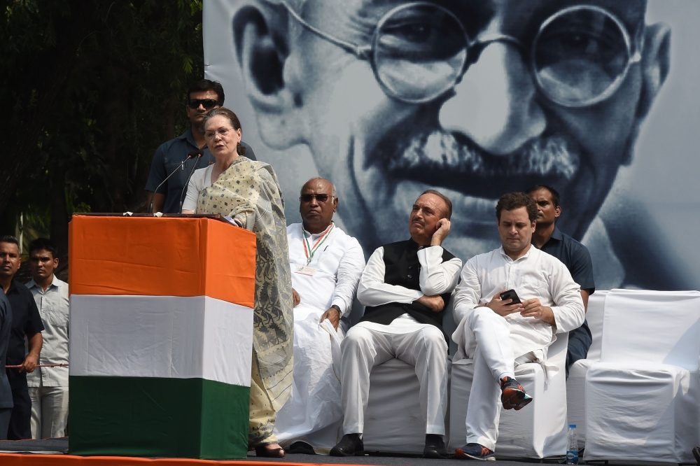 Congress Party president Sonia Gandhi speaks at an event to mark the 150th birth anniversary of Mahatma Gandhi, as her son Rahul Gandhi (R) looks at his phone behind her, in New Delhi on October 2, 2019.  AFP / Money Sharma
 