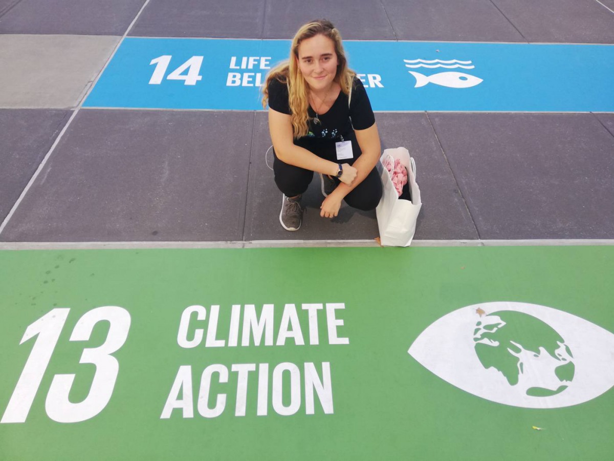 South African climate activist Zoe Prinsloo poses in front of a floor mural showing Sustainable Development Goal number 13, 