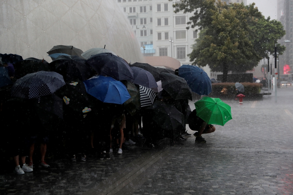 Anti-government protesters shelter from the rain under their umbrellas at the start of a demonstration in Tsim Sha Tsui district, in Hong Kong, China October 6, 2019. REUTERS/Susana Vera
 