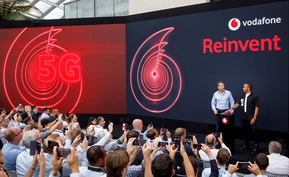 Vodafone UK CEO Nick Jeffery and Formula One racing car driver Lewis Hamilton attend the launch of Vodafone UK 5G mobile data network in London on July 3, 2019. AFP / Tolga Akmen
