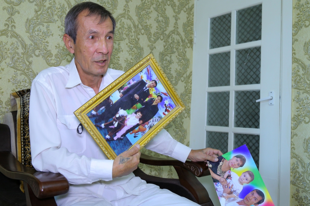 Uzbek journalist and former prisoner Dilmurod Said holds photos of his wife and daughter, who died in a 2009 car crash en route to visit him in a jail, during an interview with AFP in Tashkent on July 26, 2019.  AFP / Temur Ismailov 


