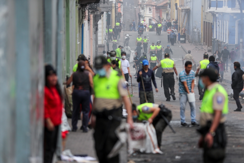 Police officers clean up the remains of a barricade after a protest against Ecuador's President Lenin Moreno's austerity measures in Quito, Ecuador, October 8, 2019. REUTERS/Ivan Alvarado