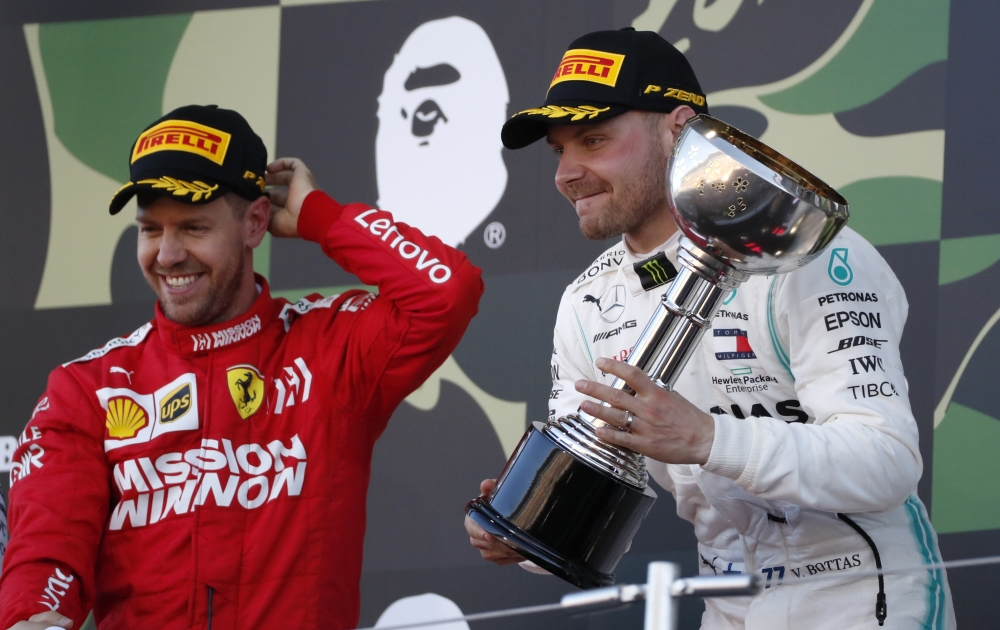 Mercedes' Valtteri Bottas celebrates with the trophy after winning the race alongside second placed Ferrari's Sebastian Vettel. REUTERS/Soe Zeya Tun