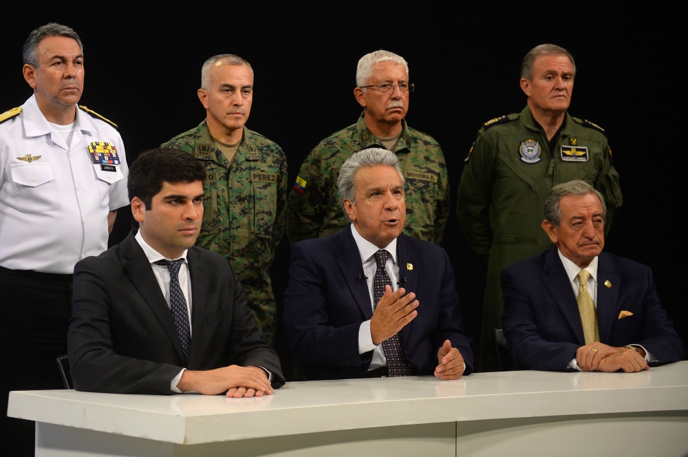 This handout image obtained courtesy of the Ecuadoran Presidency Press Office on October 7, 2019, shows Ecuadoran President Lenin Moreno (C) speaking in a national radio and television network broadcast in Guayaquil, Ecuador, alongside Vice President Otto