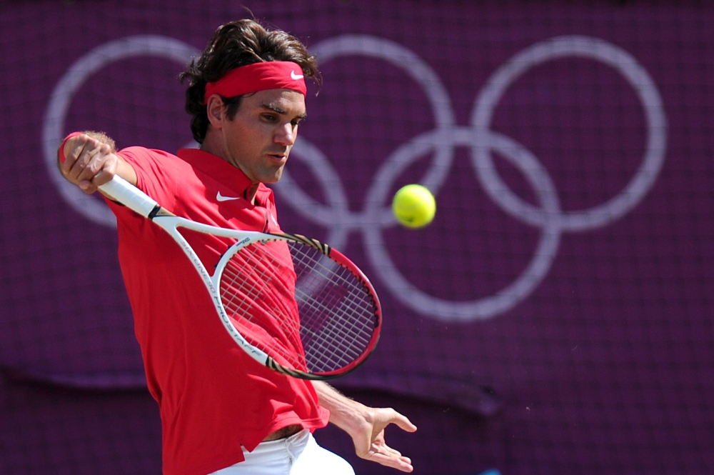 FILE PHOTO: Switzerland's Roger Federer returns the ball to Britain's Andy Murray during their London 2012 Olympic Games men's singles gold medal tennis match at Wimbledon in south London.  AFP / CARL COURT